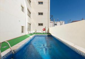 a swimming pool in front of a building at Hotel Toboso Almuñécar in Almuñécar