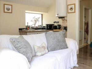 a white couch with pillows on it in a kitchen at Lannlyvri Lodge in Bodmin +6 photos