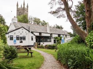 a building with picnic tables in front of it at Lannlyvri Lodge in Bodmin