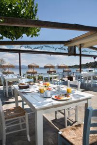 Almira Mare في خالكيذا: طاولة بيضاء عليها طعام على شاطئ