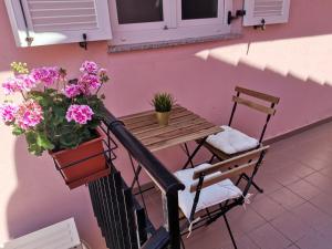 einen Balkon mit einem Tisch, einer Bank und Blumen in der Unterkunft Apartman Petra in Premantura