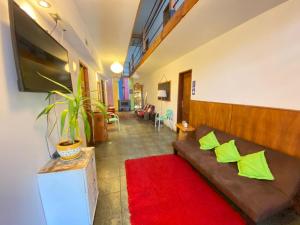 uma sala de estar com um sofá e um tapete vermelho em Pucontours Hostal em Pucón