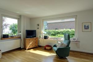 a living room with a chair and a television at Haus Tapken mit Meerblick in Varel