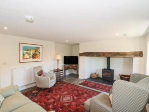 a living room with couches and a fireplace at Lilac Cottage in Wells