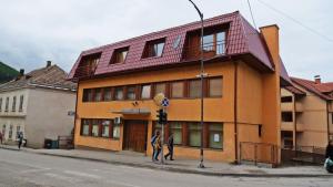 um edifício numa esquina com duas pessoas do lado de fora em Apartmani Bambola em Višegrad