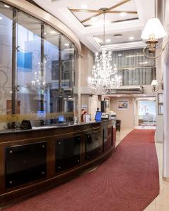 a large lobby with a reception desk and a chandelier at Hotel Metropol in San Miguel de Tucumán