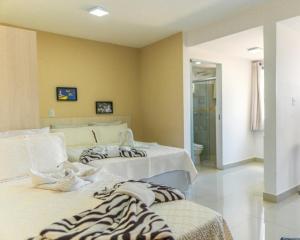 a room with two beds and a bathroom at Hotel Areião in Goiânia