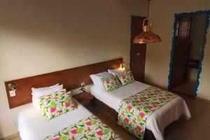 a hotel room with two beds and a lamp at Balsora Hotel Boutique in La Tebaida
