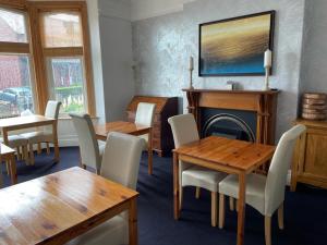 uma sala de jantar com mesas e cadeiras e uma lareira em Birtley House Bed and Breakfast em Robin Hood's Bay