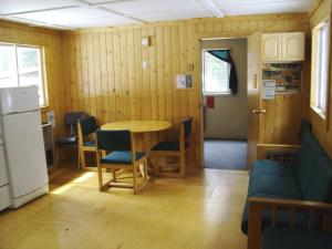a room with a table and chairs and a refrigerator at HI Mosquito Creek Hostel in Lake Louise