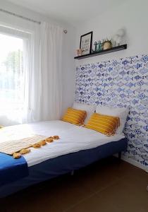 een slaapkamer met een bed met een blauwe en witte muur bij Apartamenty Amarel in Stegna