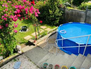 una bañera azul en un jardín con flores rosas en Chambre Hote Urban Chic proche Bagnoles SDD privative au Calme, en La Ferté-Macé