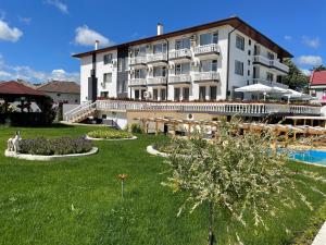 a large white hotel with a pool and a resort at Hotel Elit in Kirkovo