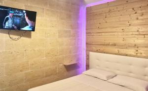 SavaにあるCasa Celesteのレンガの壁のベッドルーム(テレビ付)