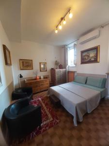Appartamento "Da Mamma Agnese" في غورغونزولا: غرفة نوم بسرير واريكة وكرسي