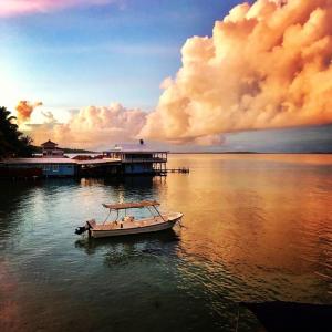 a small boat in the water near a dock at RIVA B&B in Bocas del Toro