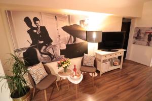 ein Wohnzimmer mit einem Sofa und einem Flachbild-TV in der Unterkunft Eva Twin Apartments in Bukarest