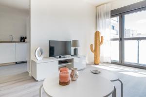 salon ze stołem, telewizorem i kaktusem w obiekcie Málaga estación centro playa w Maladze