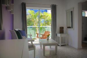 a living room with a large window with chairs and a table at Hotel Checkin El Cortecito Beach in Punta Cana