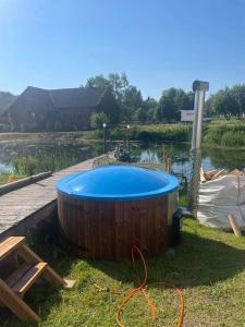 una gran bañera de madera junto a un cuerpo de agua en Torma Puhkemaja ja Glämping, en Torma