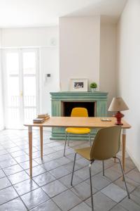 - une table et des chaises dans une pièce dotée d'une cheminée dans l'établissement Casa Rubini, à Teramo