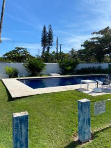 a swimming pool in a yard with some grass at Pousada Vila Novo Tempo in Guarujá