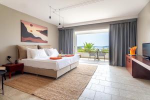 a bedroom with a bed and a tv and a balcony at Hotel Podstine in Hvar