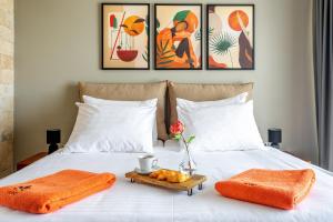 a bed with orange towels and a tray of food on it at Hotel Podstine in Hvar