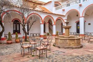 dziedziniec ze stołem, krzesłami i fontanną w obiekcie Hostal Colonial Potosi w mieście Potosí