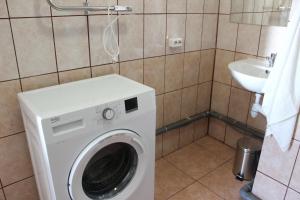 una lavatrice in bagno con lavandino di White box apartment a Liepāja