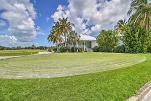 a golf course with a house and palm trees at Charming Boho Breeze Retreat with Pool Access in Key West