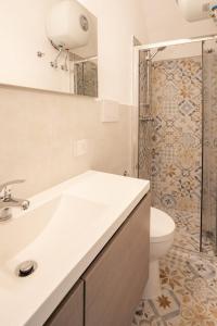 een badkamer met een wastafel, een toilet en een douche bij La Finestrella in Parabita
