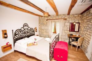 a bedroom with a bed and a stone wall at Boutique Villa Pucinum in Buzet