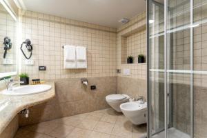 a bathroom with a toilet and a sink and a shower at Hotel Podstine in Hvar
