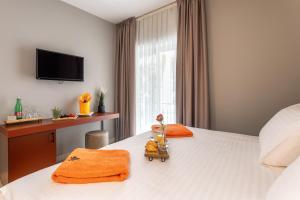 a bedroom with a bed with a desk and a television at Hotel Podstine in Hvar