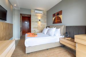 a bedroom with a large white bed and a flat screen tv at Hotel Podstine in Hvar