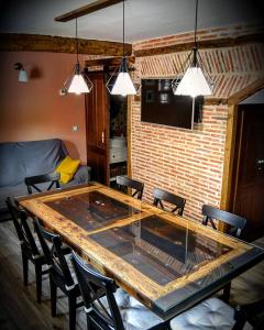 una gran mesa de madera en una sala de estar con sillas en Casa Rural La Genciana VALMALA, en Valmala