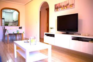 瓜爾達馬爾·德爾·塞古拉的住宿－Los Naranjos，客厅配有电视和白色桌子。
