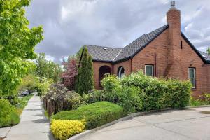 une maison en briques rouges avec un jardin en face de celle-ci dans l'établissement Authentic Midtown Reno Cottage Less Than 1 Mi to Riverwalk, à Reno