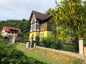 a yellow and black house with a fence at Ferienwohnung Sabine in Schmalkalden