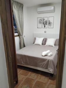 1 dormitorio con 1 cama con sábanas y almohadas blancas en Casa Mirlo, en Montmesa