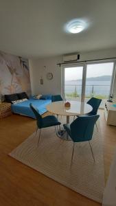 a room with a bed and a table and chairs at Marula Apartment in Račišće