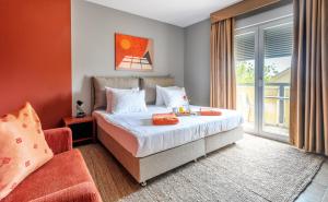 a bedroom with a bed and a chair and a window at Hotel Podstine in Hvar