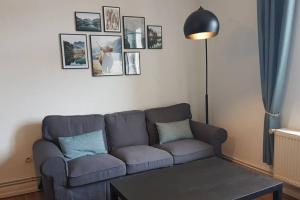 Una sala de estar con un sofá y cuadros en la pared. en Audun-Le-Tiche - Appartements 3 chambres, en Audun-le-Tiche