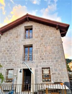 um grande edifício de pedra com janelas em Casa Rural del Tío Maino em Becerril de la Sierra