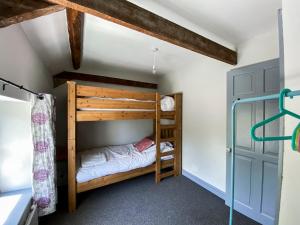 a bedroom with two bunk beds in a room at Inglenook Cottage near Porthcawl and Beaches in North Cornelly