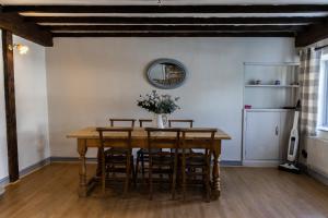 a dining room with a wooden table and chairs at Inglenook Cottage near Porthcawl and Beaches in North Cornelly