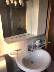 La salle de bains est pourvue d'un lavabo blanc et d'un miroir. dans l'établissement App Anita, à Premantura