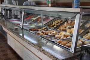 a buffet line with many different types of pastries at Hotel Chalé São Jorge in Aparecida