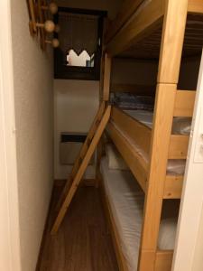 a bunk bed in a room with two bunk beds at Appartement dans chalet typiquement savoyard au pied des pistes in La Norma